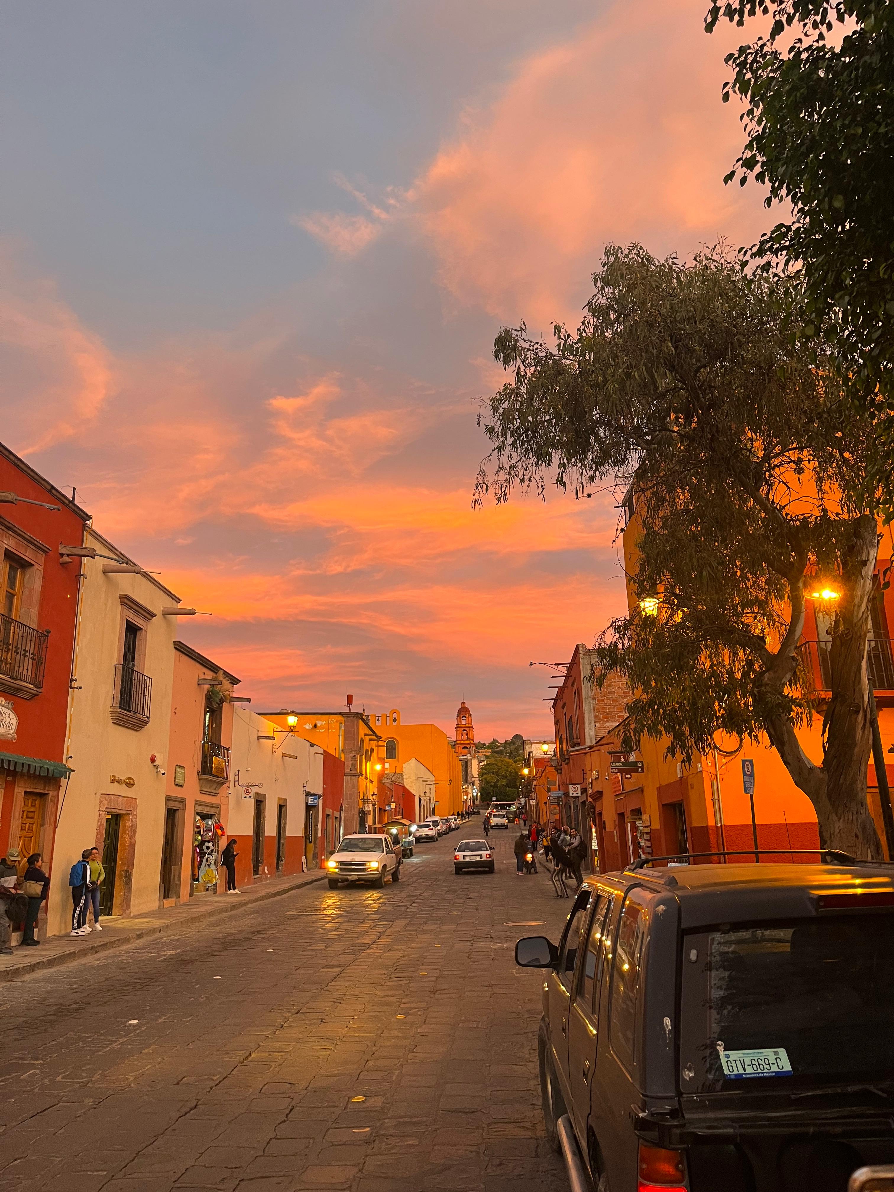 Calle empedrada de San Miguel de Allende al atardecer con bugambilias